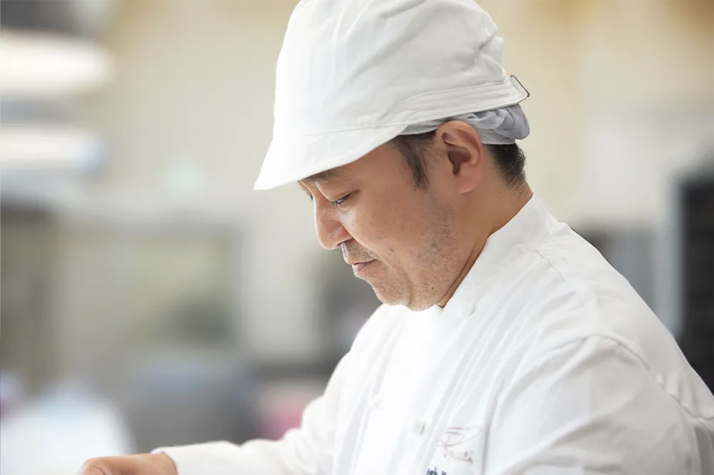 穏やかな表情で作業をするヘッドシェフ松田さんの横顔